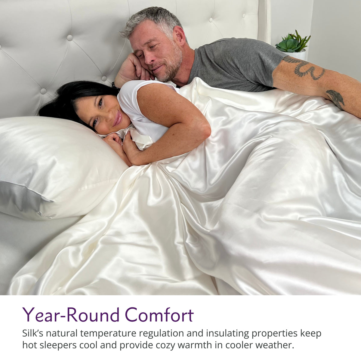 Couple cuddling on a bed with luxurious ivory silk sheets, enjoying comfort and elegance