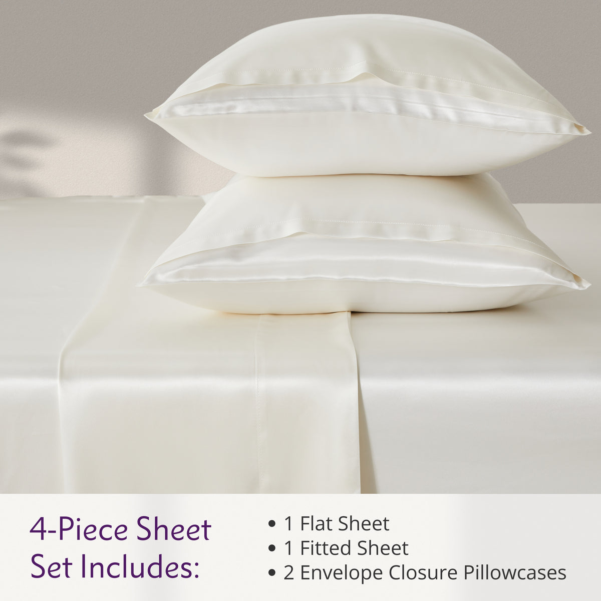 Ivory 4-piece silk sheet set with two pillowcases, a flat sheet, and a fitted sheet on a bed