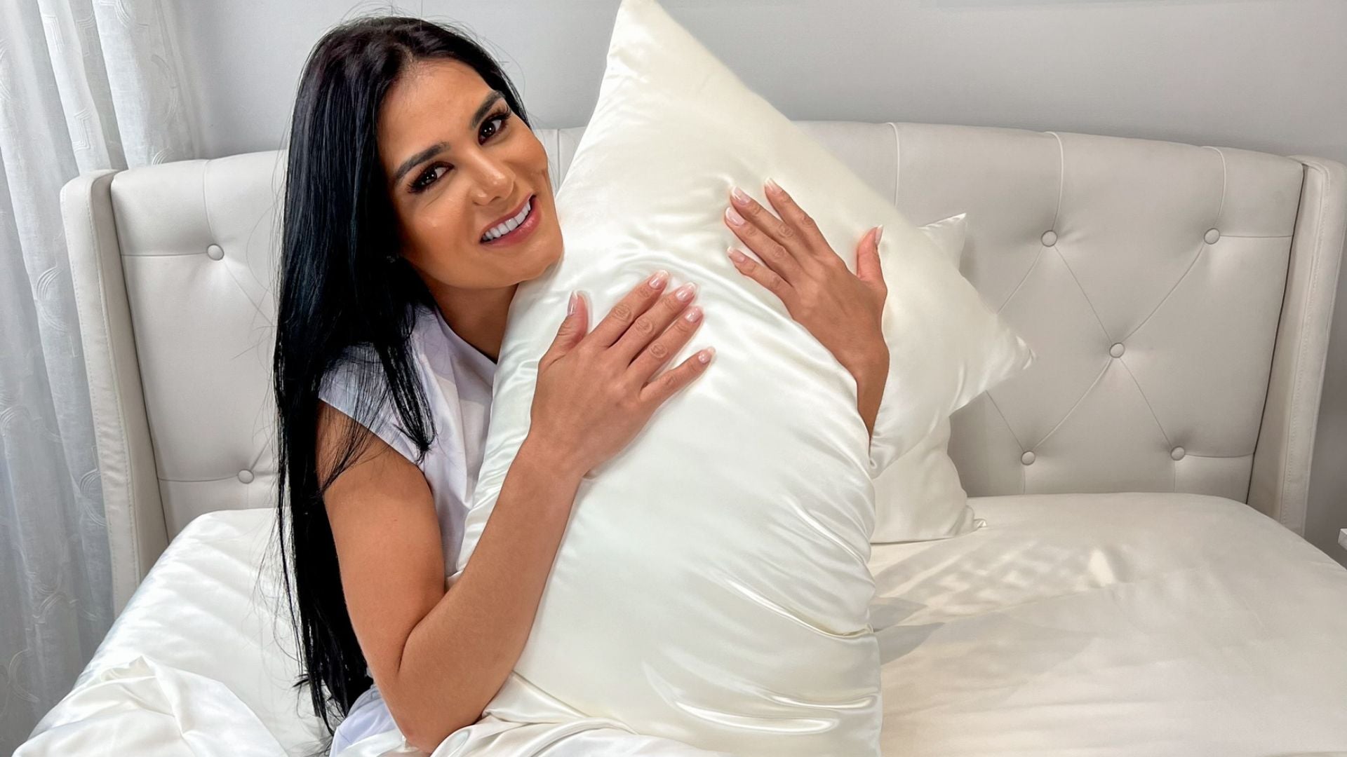 woman holding ivory silk pillowcase
