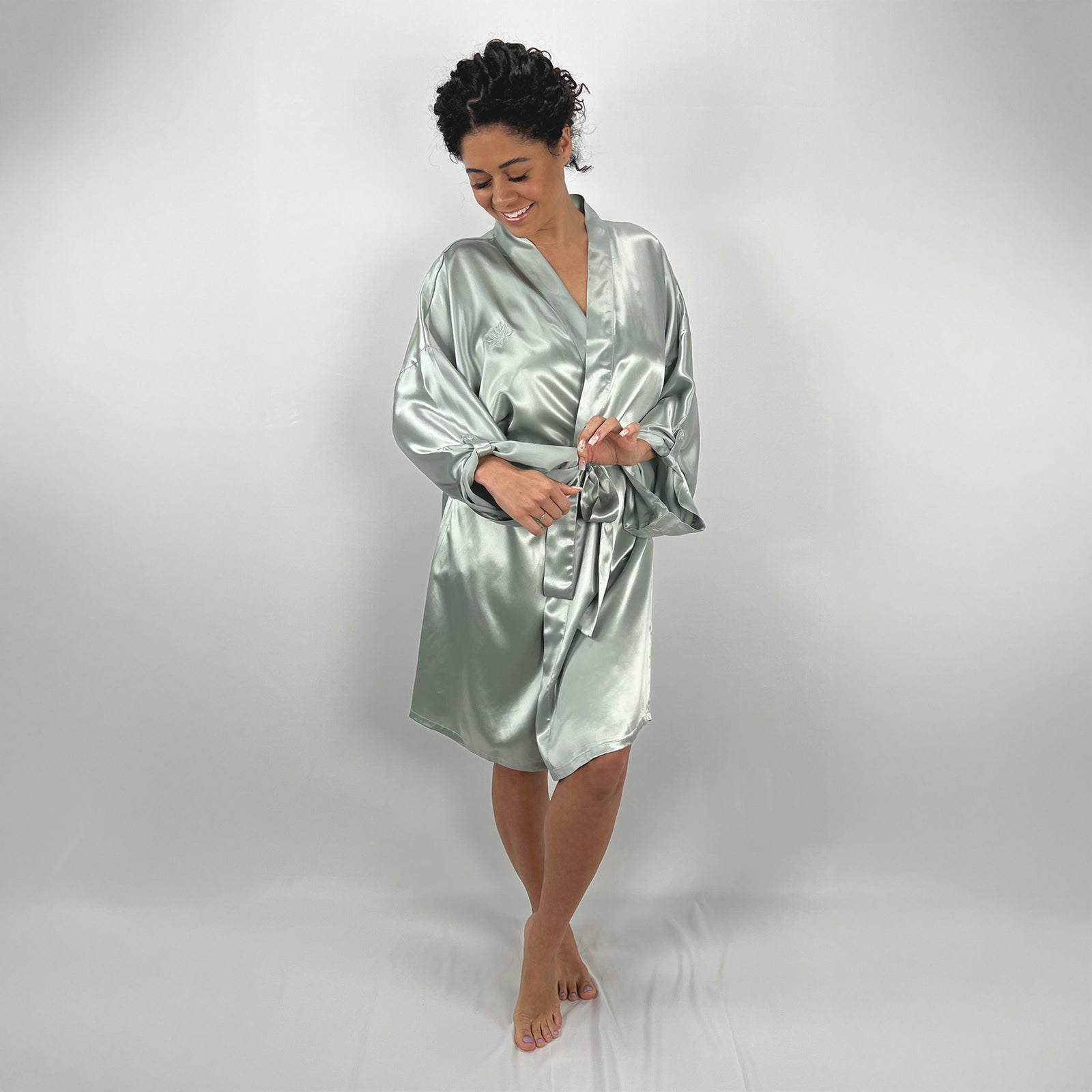 Model wearing a sage female robe, showcasing to show the front and side views 