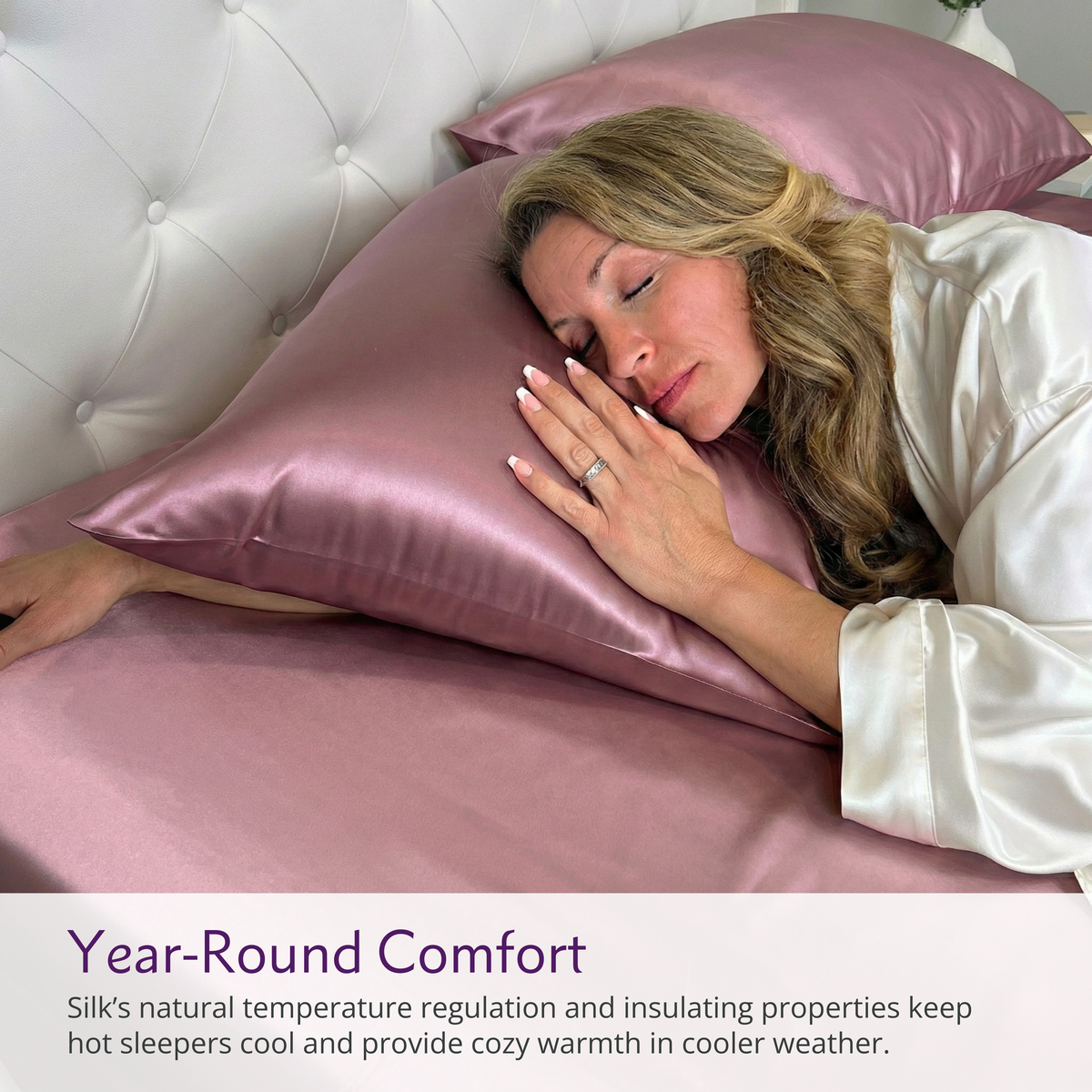A woman in a white robe sleeps on 22 momme silk sheets with pink pillowcases, promising year-round comfort.
