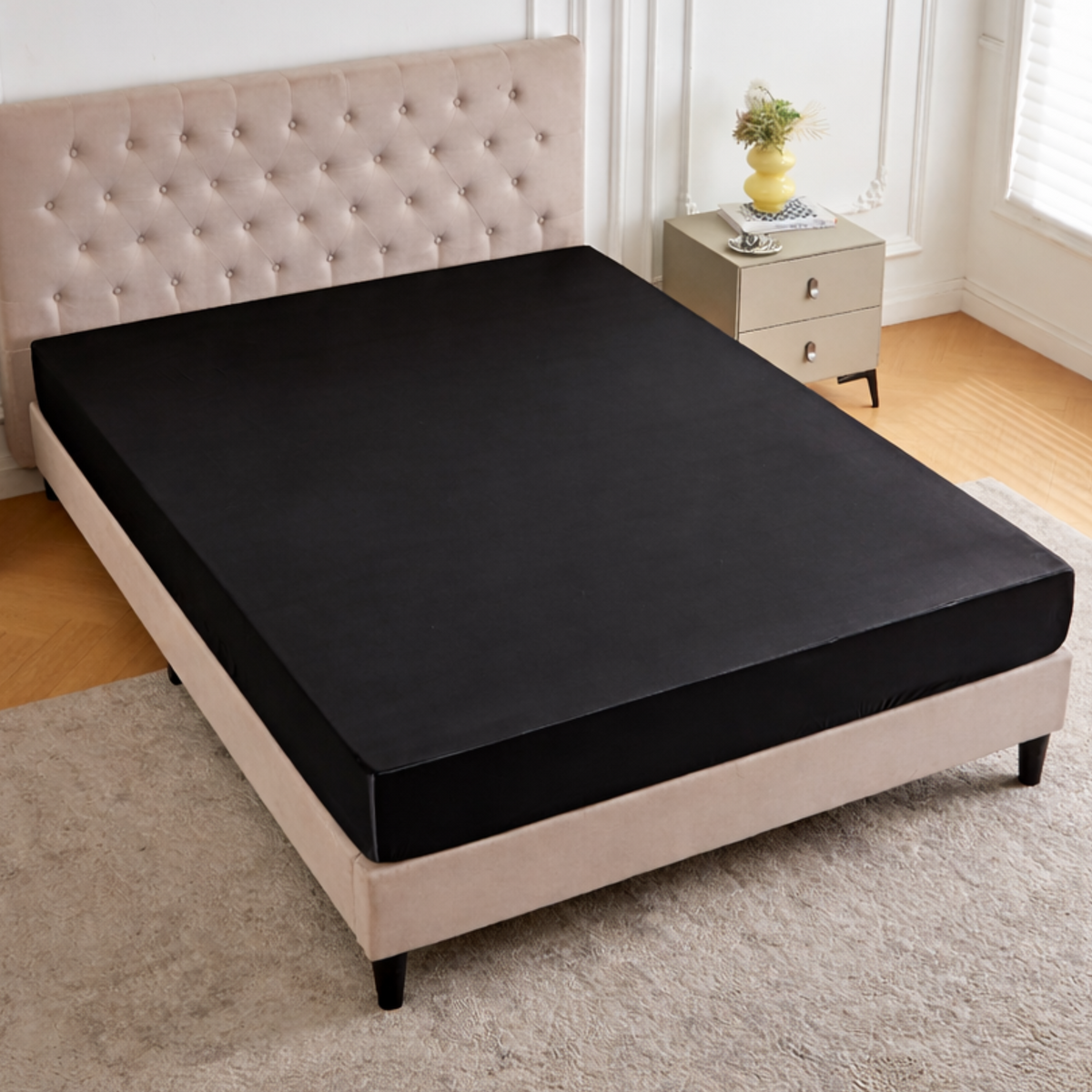 Black fitted bed sheet on a bed in a bedroom setting