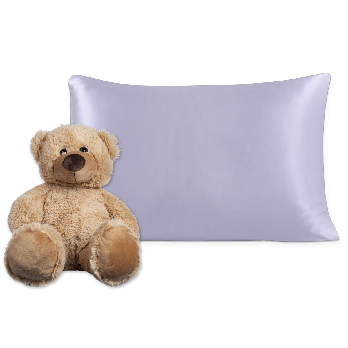 A light brown teddy bear sits next to a smooth, silk light purple pillow on a white background.