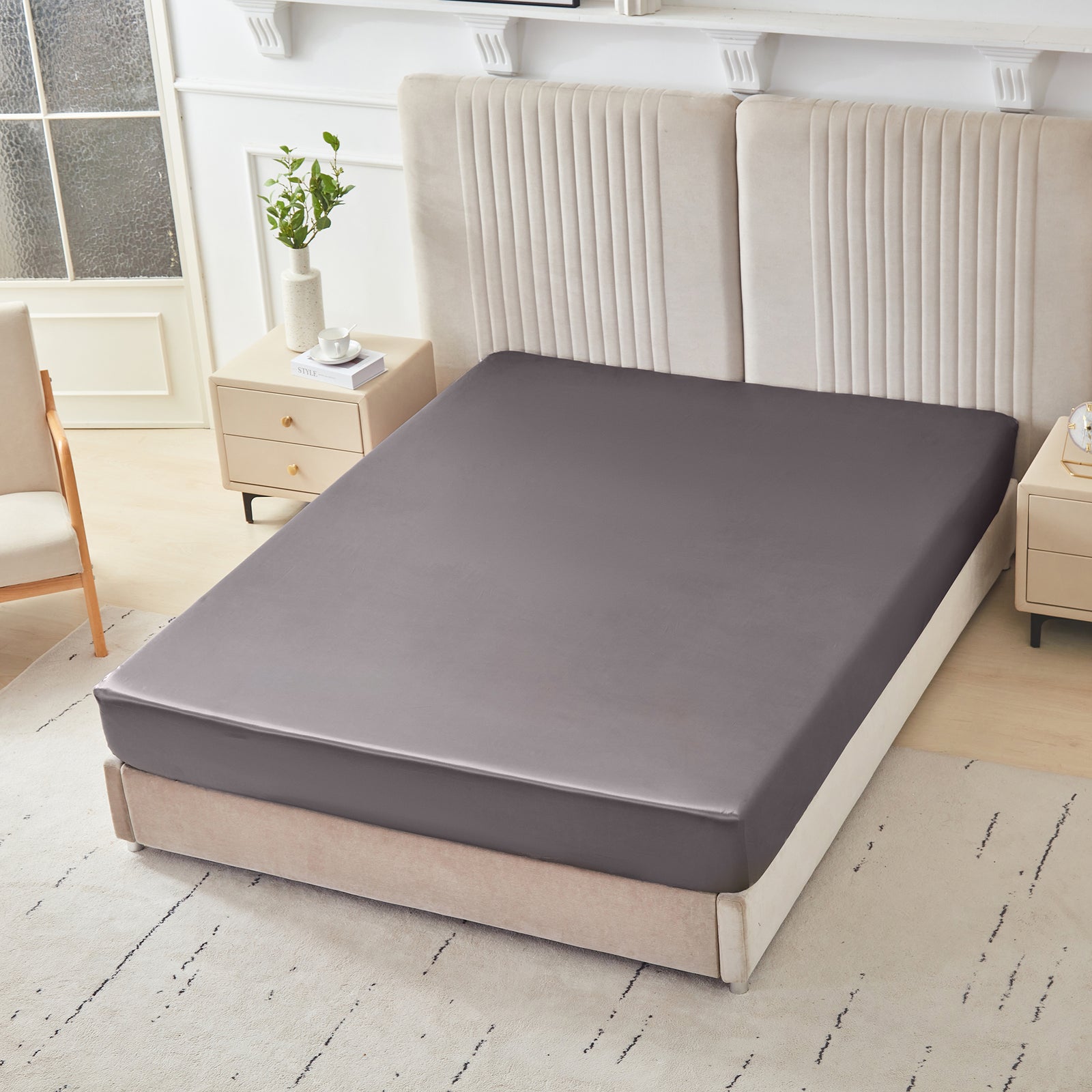 22 momme silk fitted sheet in Gunmetal on bed with upholstered headboard in a cozy bedroom setting