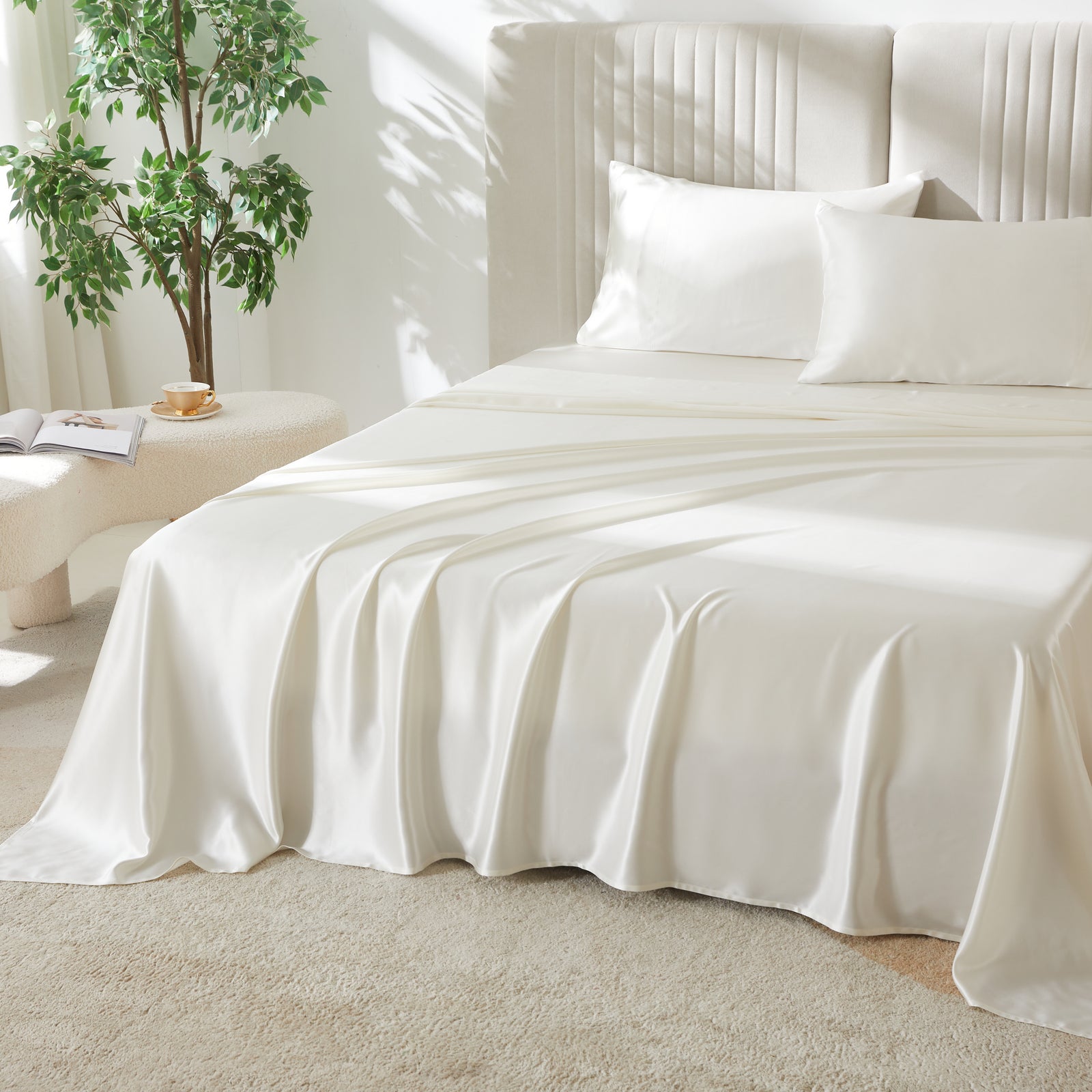 White silk flat sheet draped over a neatly made bed in a bright, modern bedroom