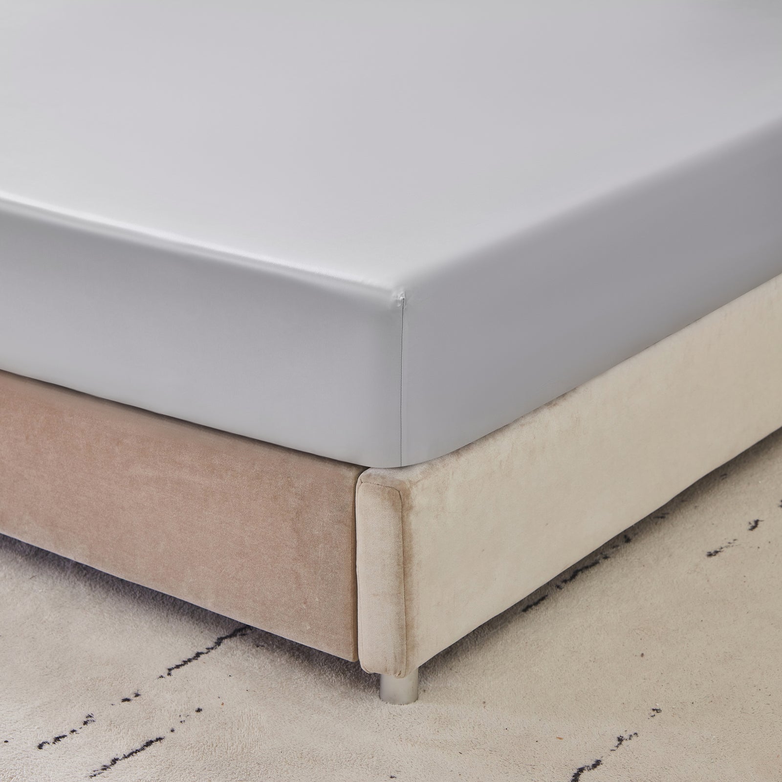 22 momme silk fitted sheet in Gunmetal on bed with upholstered headboard in a cozy bedroom setting