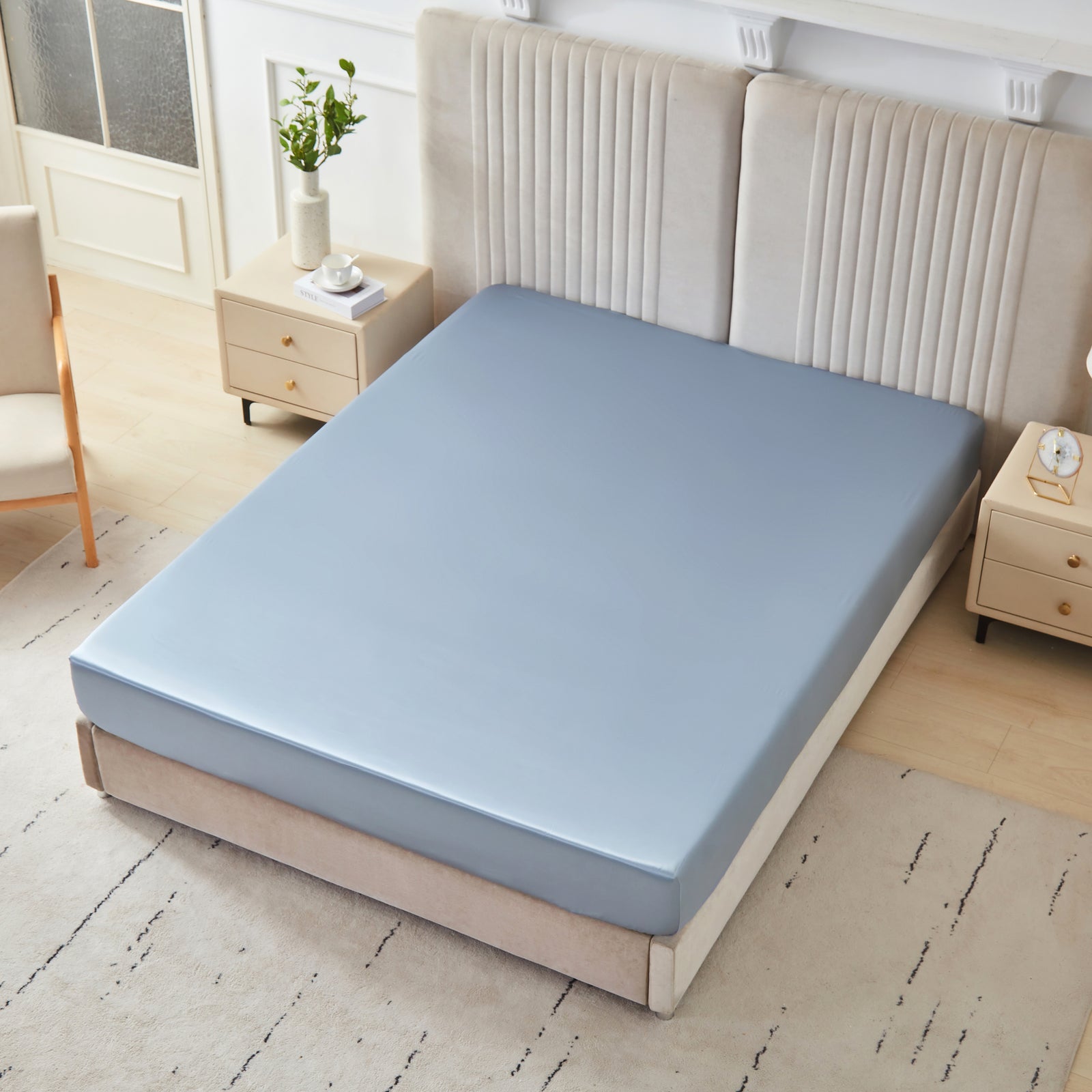 22 momme silk fitted sheet in Steel Blue on bed with upholstered headboard in a cozy bedroom setting